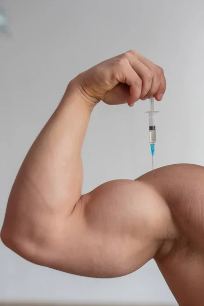 Gros plan des biceps masculins. bodybuilder masculin méconnaissable se met lui-même une injection de testostérone. Athlète sans visage prend de l'hormone de croissance. Vertical  . — Photo