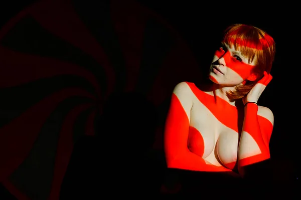 붉은 조명을 입은 아름다운 알몸의 여성의 초상화. 붉은 머리 여자의 피부에 빛과 그림자의 거리. — 스톡 사진