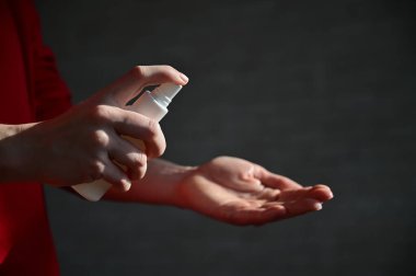 Kadın eli antiseptik spreyle yakın çekim. Koronavirüsü önlemek için bir kadın avucunun içini antibakteriyel bir maddeyle dezenfekte eder. Karantinada kişisel temizlik.