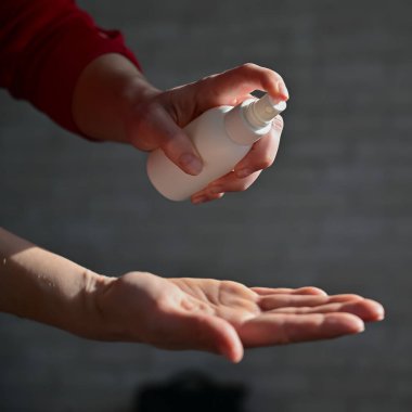 Kadın eli antiseptik spreyle yakın çekim. Koronavirüsü önlemek için bir kadın avucunun içini antibakteriyel bir maddeyle dezenfekte eder. Karantinada kişisel temizlik.