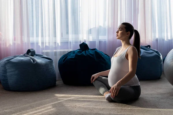 Hamile kadın yoga yapıyor. Üçüncü üç aylık dönemde bir kadın pilates yapıyor. Doğuma hazırlanmak için dersler. Bebeği bekliyorum.. — Stok fotoğraf