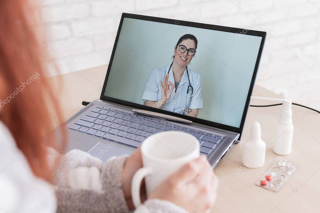A woman is on sick leave. The patient consults a doctor online. Video chat with the doctor on the laptop. The therapist gives tips for treating the disease.