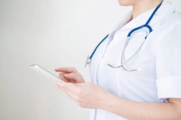 Felismerhetetlen női orvos használja a mobilját. Az egészségügyi dolgozó okostelefonon kommunikál a betegekkel. Vágott. — Stock Fotó