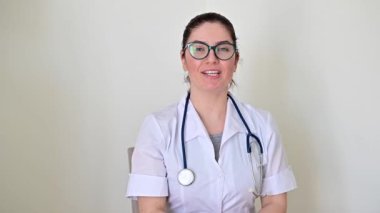 Klinikte sohbet eden genç bir doktorun portresi. Uzman hekim çevrimiçi danışmanlık yapıyor..