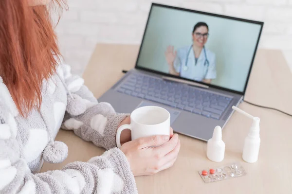 Жінка з застудою знаходиться на лікарняній відпустці і дивиться на лікаря відео-консультації для ноутбуків. Пацієнт у віддаленому призначенні. Онлайн зустріч . — стокове фото