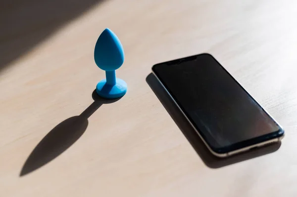 Plug anal azul sincronizado con un smartphone. Vibrador de látex que entrega para placeres carnales . — Foto de Stock