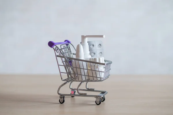 Einkaufswagen mit Pillen und Medikamenten. Verschiedene Arzneiflaschen im Mini-Trolley. — Stockfoto