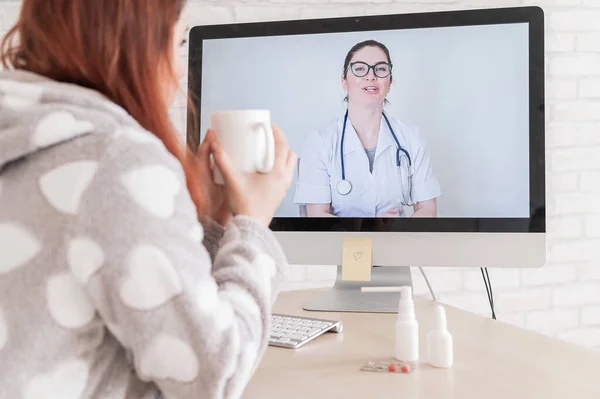 Una mujer con una enfermedad respiratoria está de baja por enfermedad y está mirando a un médico de la consulta de vídeo por computadora. El terapeuta proporciona cobertura en vivo para los pacientes. Una enfermera da consejos en línea . — Foto de Stock