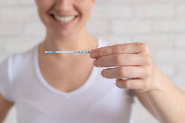 Mutlu kadın pozitif yumurtlama testi gösteriyor. Kadın doğurganlığı ve yüksek lutein hormonu kavramı. Çocuk yapmak için doğru zaman..