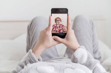 Üşütmüş bir kız yatakta yatar ve annesiyle telefonda video görüşmesi yapar. Yaşlı bir kadın grip olmuş ve kızıyla web kamerasında konuşuyor. Tecrit.