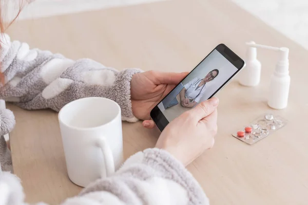 Невпізнавана жінка на онлайн-консультації з лікарем на мобільному телефоні. Дівчинка хвора і розмовляє з лікарем на відеодзвінок з дому. Крупним планом екран . — стокове фото