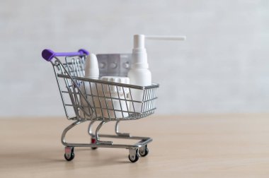 İçinde haplar ve uyuşturucular olan alışveriş arabası. Küçük bir tramvayda farklı ilaç şişeleri.