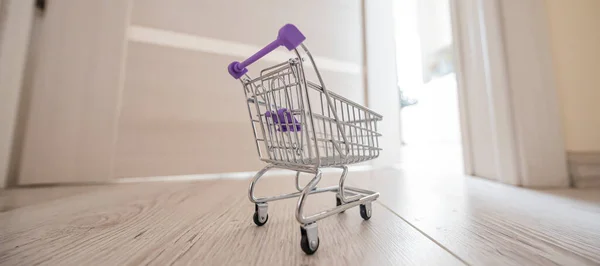 Grocery cart at the open door. Delivery of products. Mini trolley for contactless delivery. — Stock Photo, Image