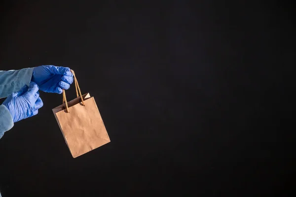 Express home delivery in the epidemic of coronavirus. Courier in gloves with a paper bag. Packaging made from eco friendly recycled material. Buying products online in quarantine. — Stock Photo, Image