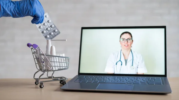 Egy barátságos orvos távoli receptet ad egy laptopon. A gyógyszerész hozzáad egy ellenszert a vírusra a mini kosárban. Online orvoslás koncepció. Rendeljen online gyógyszereket. Videohívás. — Stock Fotó