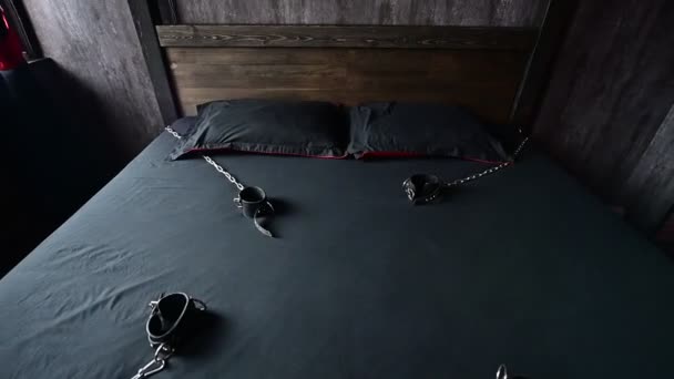 BDSM Lederen handboeien voor rollenspellen op een grijs vel. Bondage voor vleselijke genoegens. Overheersing en onderwerping. Vertrekkende camera. Geen mensen. — Stockvideo