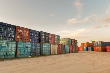 Yük konteynırları deposu. Taşımadan önce metal kutular birbiri ardına birkaç sıra yüklendi. Terminal taşıma konteynerleri.