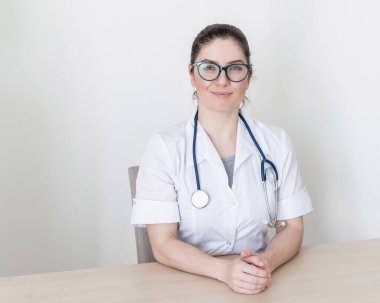 Dost canlısı doktor jestleri yapar ve kameraya konuşur. İnternet üzerinden hastalık önleme tavsiyeleri veren bir sağlık uzmanının portresi.