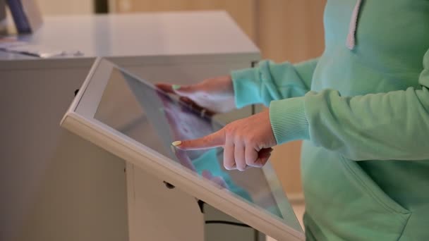 Mujer sin rostro tocando la pantalla de un dispositivo de autoservicio en una tienda. Navegador de tienda de dispositivos. Auto compra. — Vídeos de Stock