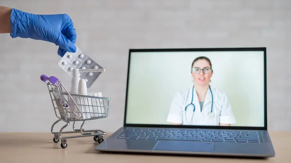 A friendly doctor gives a remote prescription on a laptop. The pharmacist adds a cure for the virus in the mini cart. Online medicine concept. Order drugs online. Video call.