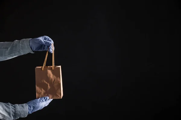 Express home delivery in the epidemic of coronavirus. Courier in gloves with a paper bag. Packaging made from eco friendly recycled material. Buying products online in quarantine. — Stock Photo, Image