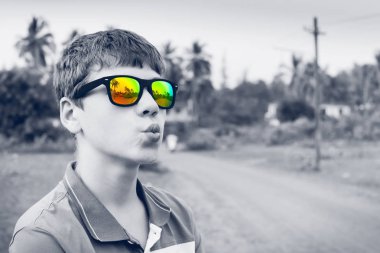 Şık siyah beyaz portre renkli ayna güneş gözlüğü ile büyüleyici genç adamın. Yaz aylarında konsept