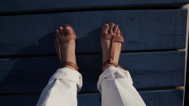 Ноги женщины, которая стоит на темно-синем деревянном пирсе и шевелит пальцами ног . — стоковое видео