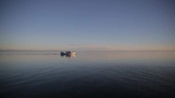 The white old boat is slowly going on the lake Baikal in the autumn evening. — Stock Video