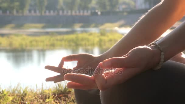 Mujer joven se sienta en pose de loto con las manos jnana mudra en el parque al aire libre . — Vídeos de Stock