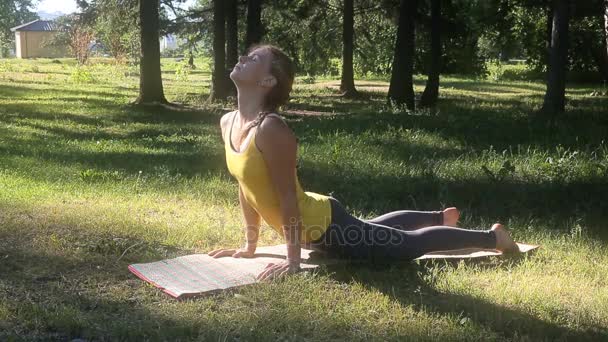 Jonge vrouw doet lichaam stretching oefening buiten in park. — Stockvideo