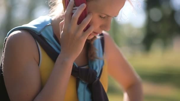 Jeune femme en vêtements de sport sérieusement parler au téléphone . — Video