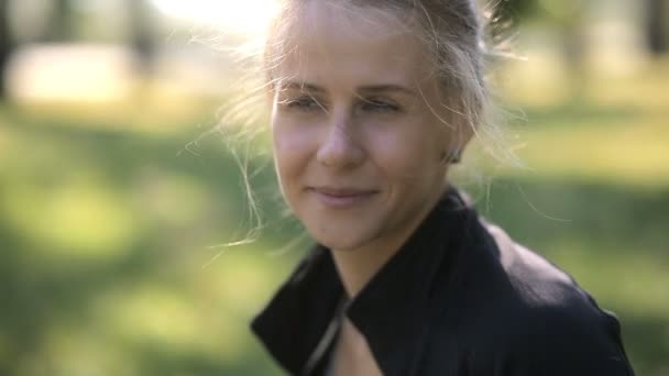 Retrato de una mujer sonriente cuyo cabello se desarrolla a partir del viento frío . — Vídeos de Stock