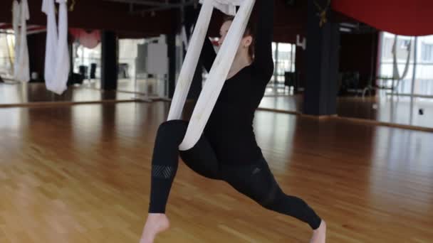 Mujer sana está teniendo un entrenamiento de yoga con mosca en el gimnasio . — Vídeo de stock