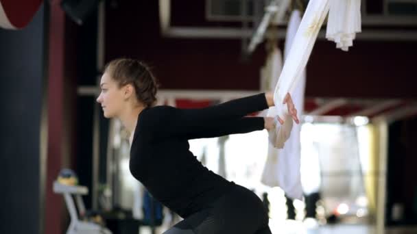 Sport kvinna fixar händerna i en luft hängmatta för yoga. — Stockvideo