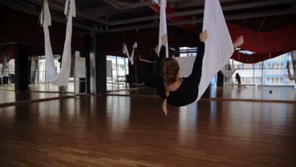 In de studio van aerial yoga draait vrouw haar hoofd een hangmat. — Stockvideo