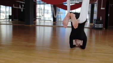 Genç kadın baş aşağı asılı hamak studio.