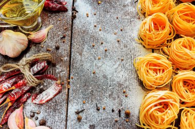 Pişmemiş spagetti veya makarna un, ayçiçek yağı, sarımsak, biber ve baharat siyah arka plan, metin için üstten görünüm yer ile