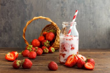 Çilek güler yüzlü veya milkshake rustik siyah arka plan üzerine kavanoz içinde