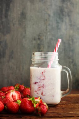 Smoothie çilek veya milkshake kavanoz ve sepet eski rustik zemin üzerine