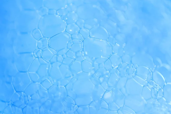 Makró megtekintése szappanos kék buborékok hab. szappanhab és textúra. Kék háttér. lágy fókusz — Stock Fotó