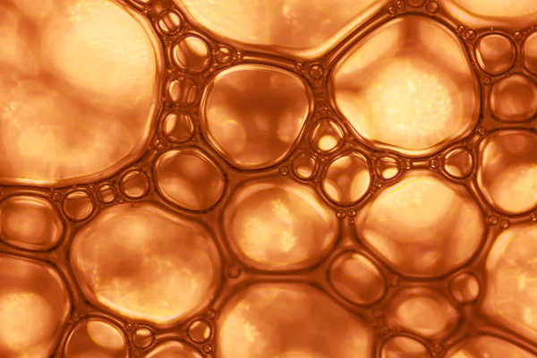 Makro görünümü sabunlu beyaz köpük kabarcıklar. sabun köpüğü ve duş doku. Mavi arka plan. yumuşak odak