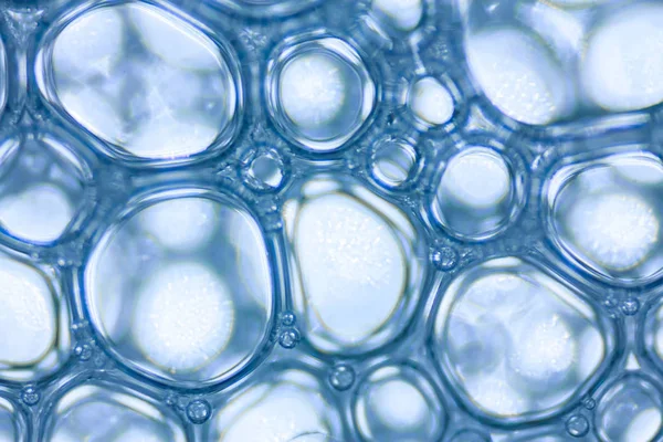 Makró megtekintése szappanos fehér hab buborékok. szappanhab és textúra. Kék háttér. lágy fókusz — Stock Fotó