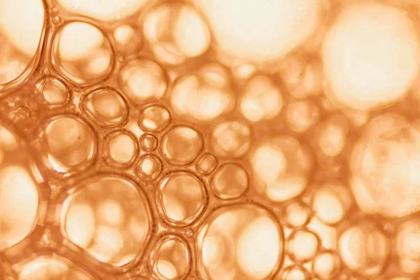 Makro görünümü sabunlu beyaz köpük kabarcıklar. sabun köpüğü ve duş doku. Mavi arka plan. yumuşak odak