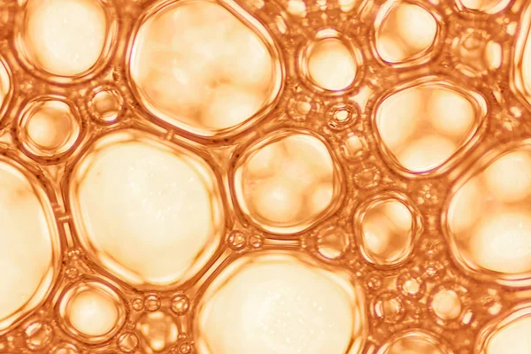 Makro görünümü sabunlu beyaz köpük kabarcıklar. sabun köpüğü ve duş doku. Mavi arka plan. yumuşak odak