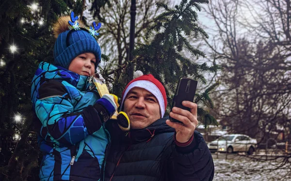 Father and son take a selfie near the Christmas tree — Stock Photo, Image