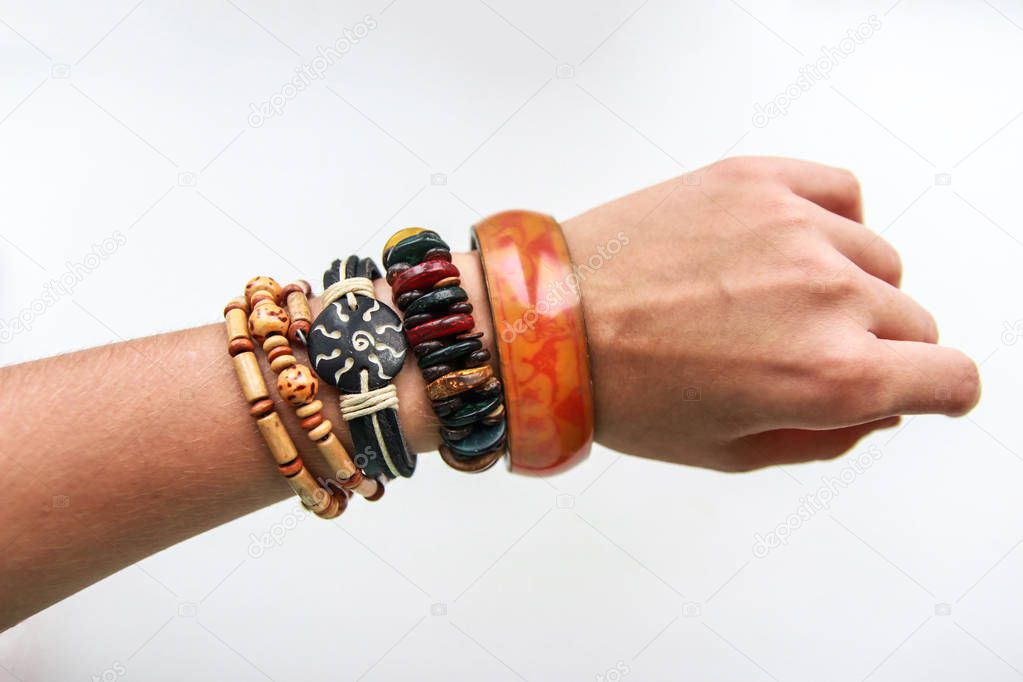 Ethnic bracelets on a thin female hand on white background
