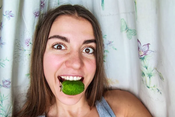 Funny girl eating berries feijoa — Stock Photo, Image