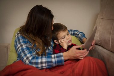 Anne ve oğlu tablet yatakta bak