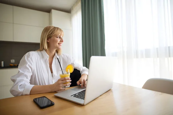 Hermosa mujer embarazada de negocios y sonriendo mientras está sentado en el lugar de trabajo en casa — Foto de Stock