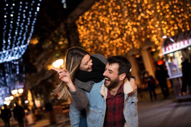 Genç ve mutlu bir çift büyük bir şehirde gece iyi vakit geçiriyor.